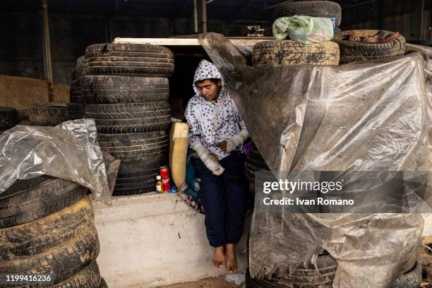 Algerian migrant named Adir in his shelter inside an abandoned industrial warehouse, with his arms in plaster, after the injuries suffered by the...