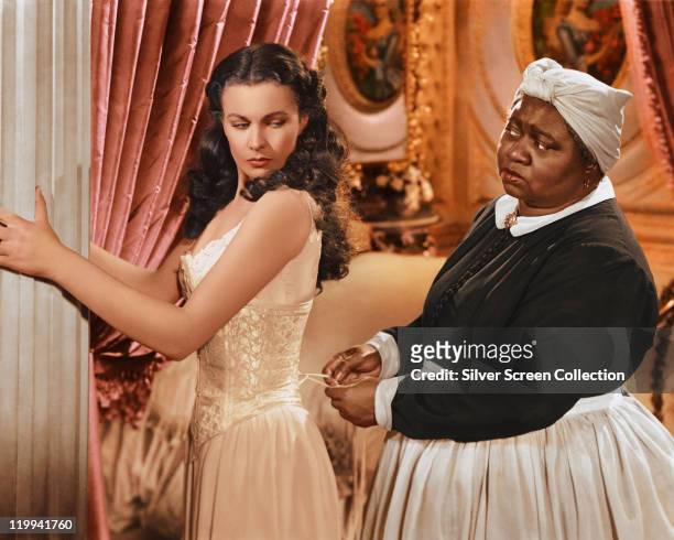 Vivien Leigh , British actress, has her corset tightened by Hattie McDaniel , US actress, in a publicity still issued for the film, 'Gone with the...
