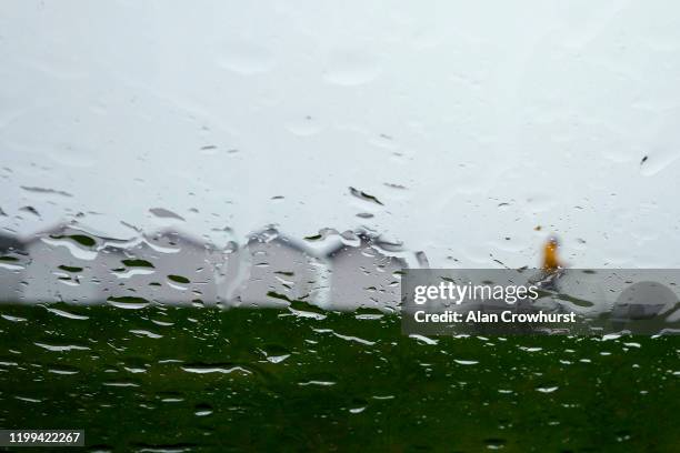 Walker wearing a yellow jacket is not put off by the weather as they stroll along the promenade as Storm Brendan heads in on January 14, 2020 in...