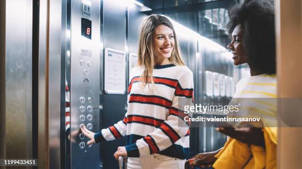 female friends arriving at the hotel - elevator stock pictures, royalty-free photos & images
