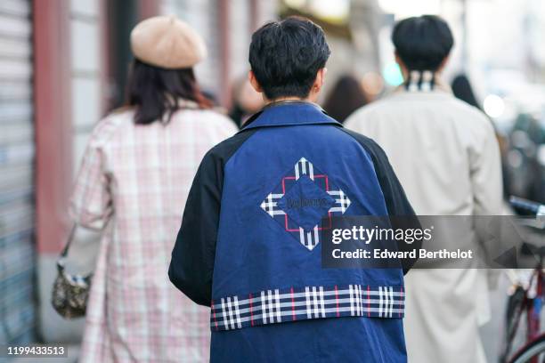 Guest wears a Burberry blue coat with printed checked patterns, a patched logo, outside Reshake, during Milan Fashion Week Menswear Fall/Winter...