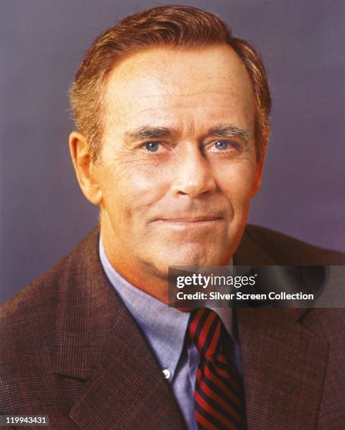 Henry Fonda , US actor, wearing a tweed jacket, a blue shirt, and a red-and-black striped tie, in a studio portrait, against a lilac background,...