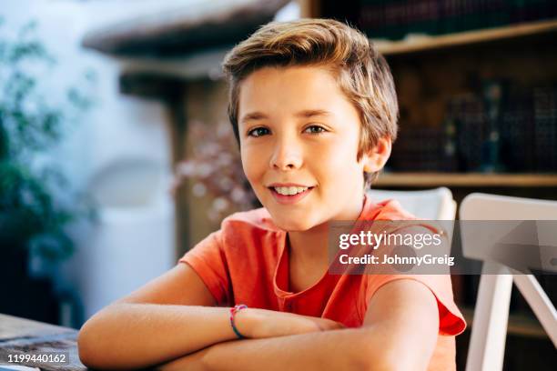 informal portrait of young boy sitting at dining table - pré adolescente imagens e fotografias de stock