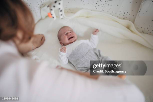 baby boy lying in crib and crying - moms crying in bed stock pictures, royalty-free photos & images