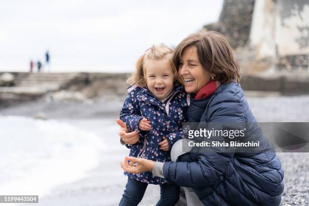 grand-mère et petite-fille sur la plage en hiver - nephew photos et images de collection