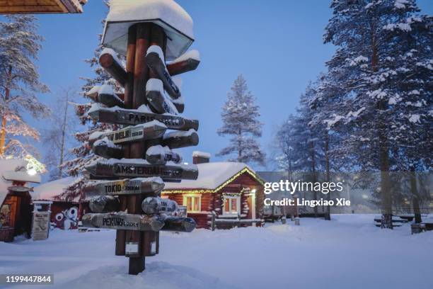 wooden post with directional signs in santa claus village, rovaniemi, lapland, finland - finland igloo stock pictures, royalty-free photos & images