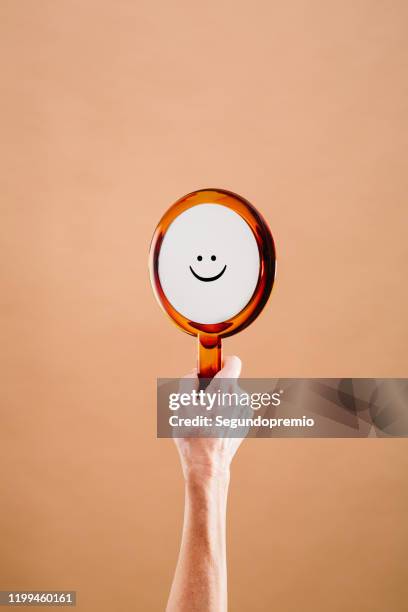 mano sosteniendo un espejo con un smiley - spiegel stock-fotos und bilder