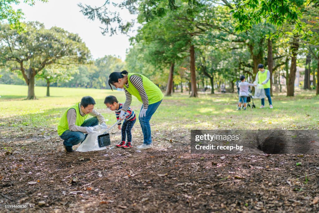 ボランティアの仕事として公共公園を掃除する家族