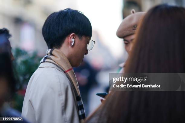 Guest wears a brown checked scarf, a trench coat, glasses, outside Reshake, during Milan Fashion Week Menswear Fall/Winter 2020/2021, on January 13,...