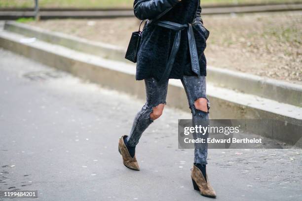 Guest wears ripped gray jeans and brown suede shoes, outside Reshake, during Milan Fashion Week Menswear Fall/Winter 2020/2021, on January 13, 2020...