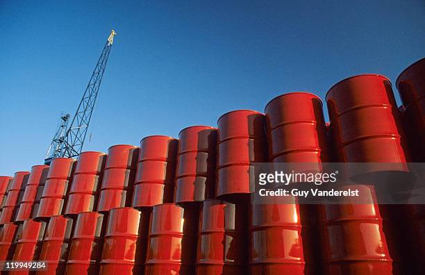 red metal barrels against blue sky. - red oil drum stock-fotos und bilder
