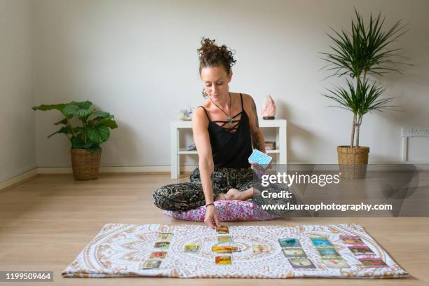 woman reading tarot cards in spiritual room - tarot cards stock pictures, royalty-free photos & images