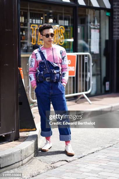 Guest wears tortoise-shell sunglasses, a pink top with black and white pictures print, a navy blue denim jumpsuit with rolled-up hem, pink socks,...