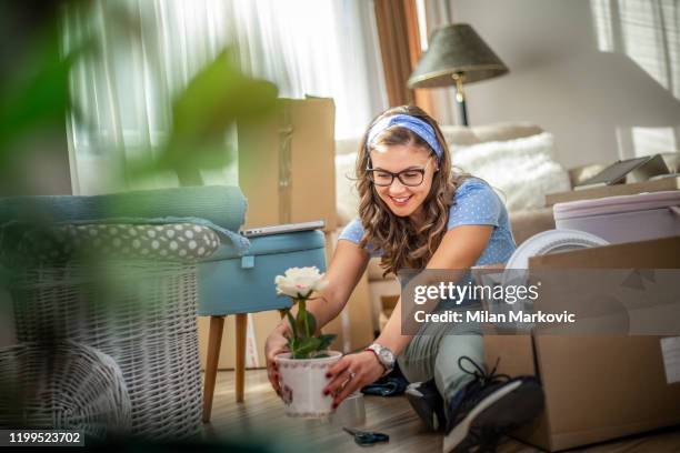 young woman moves things to a new home - first apartment stock pictures, royalty-free photos & images