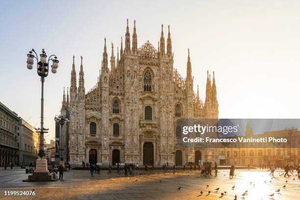 piazza del duomo (cathedral square) at sunrise, milan, italy. - daily life at duomo square milan stock pictures, royalty-free photos & images