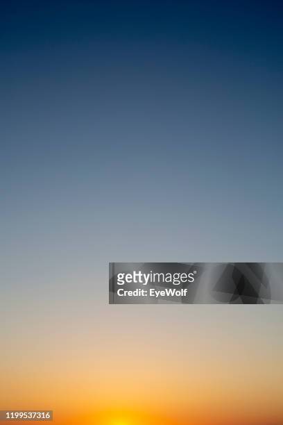 sunset sky color gradient from orange to dark blue - imbrunire foto e immagini stock