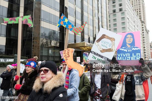 Marcher with a sign that says "Vote With Intersectionality In Mind" with arms intersecting and on the arms say, "Black Lives Matter", "Me Too", "My...