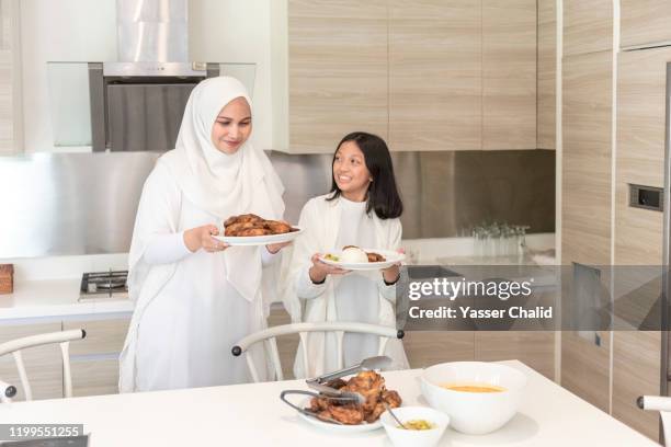 mother and daughter preparing meal - muslims prepare for eid in indonesia stock-fotos und bilder