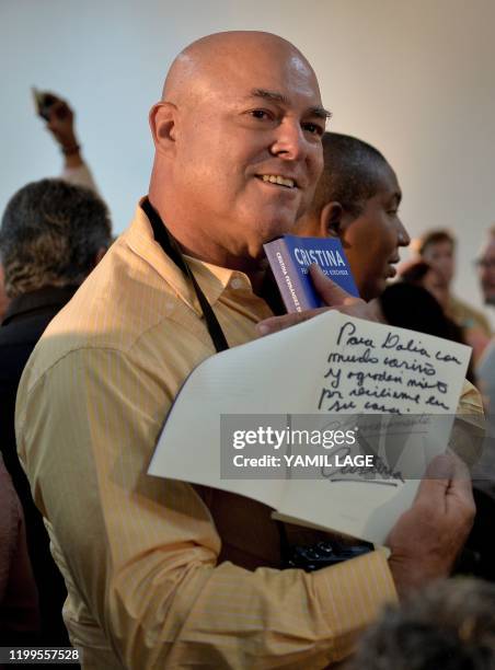 Cuban late leader Fidel Castro's son Alex Castro shows a copy of Argentine Vice-President Cristina Kirchner's book "Sincerely" dedicated to his...