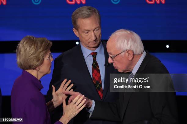 Sen. Elizabeth Warren and Sen. Bernie Sanders speak as Tom Steyer looks on after the Democratic presidential primary debate at Drake University on...