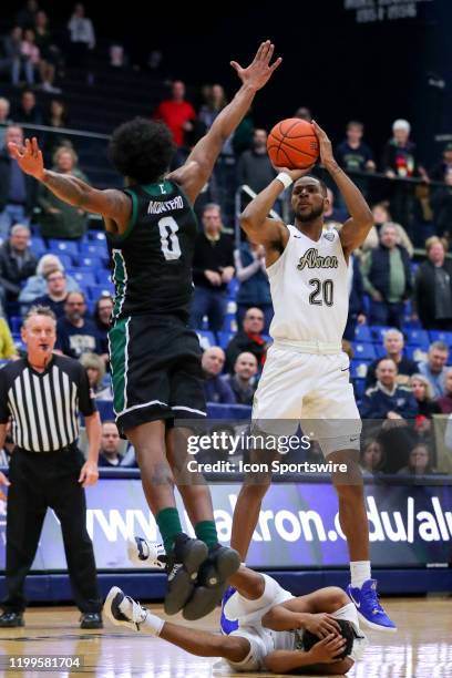 Akron Zips forward Xeyrius Williams buries the game winning 3-point shot over Eastern Michigan Eagles guard Yeikson Montero with 0:04.1 seconds left...