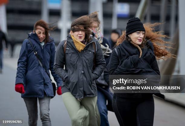 People walk against strong wind on the Erasmusbrug bridge, in Rotterdam, on February 9, 2020. During the storm Ciara in Harlingen, The Netherlands,...