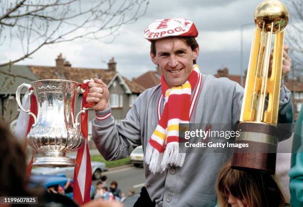 Liverpool player manager Kenny Dalglish celebrates with the trophies on the teams homecoming bus parade after completing the Football League and FA...