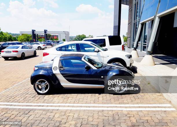 tiny smart roadster parkt in johannesburg einkaufszentrum - kleinwagen stock-fotos und bilder