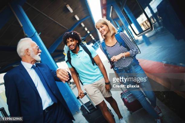 young couple boarding a train. - asking time stock pictures, royalty-free photos & images