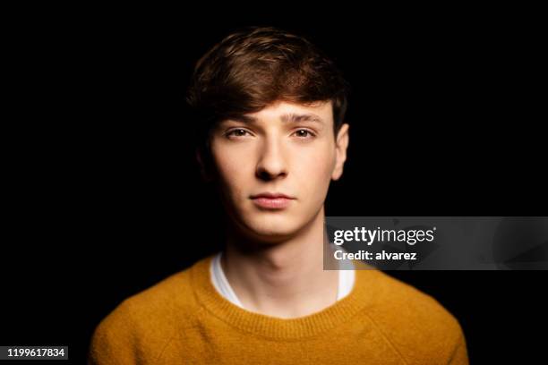 portrait of a young guy in casuals against black background - young caucasian man on black stock pictures, royalty-free photos & images