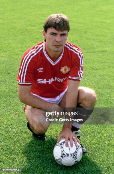 Manchester United player Brian McClair pictured kneeling with an Adidas match ball during the Squad photo call ahead of the 1987/88 season, possibly...