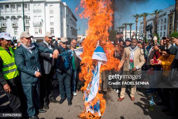 Moroccans burn the Israeli flag during a demonstration against the US Middle East peace plan in the capital Rabat on February 9, 2020. - Morocco has...