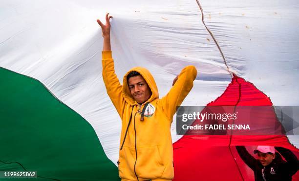 Moroccan youth waves the Palestinian flag during a demonstration against the US Middle East peace plan in the capital Rabat on February 9, 2020. -...