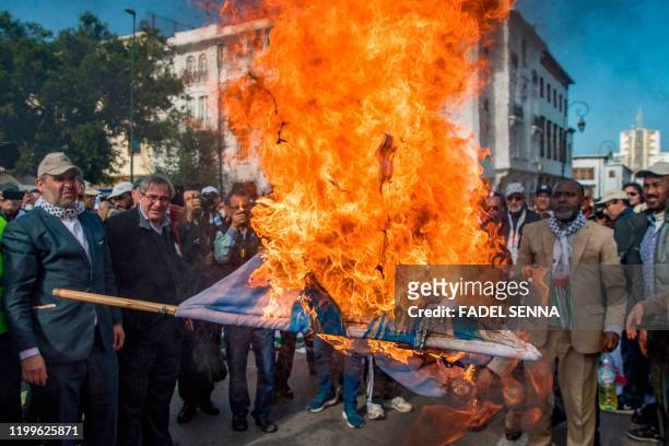 Moroccans burn the Israeli flag during a demonstration against the US Middle East peace plan in the capital Rabat on February 9, 2020. - Morocco has...