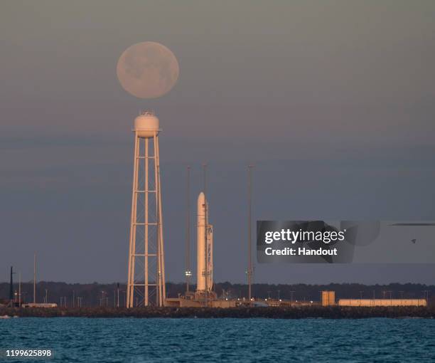 In this NASA handout, A Northrop Grumman Antares rocket carrying a Cygnus resupply spacecraft is seen at sunrise as the Moon sets on Pad-0A, Sunday,...