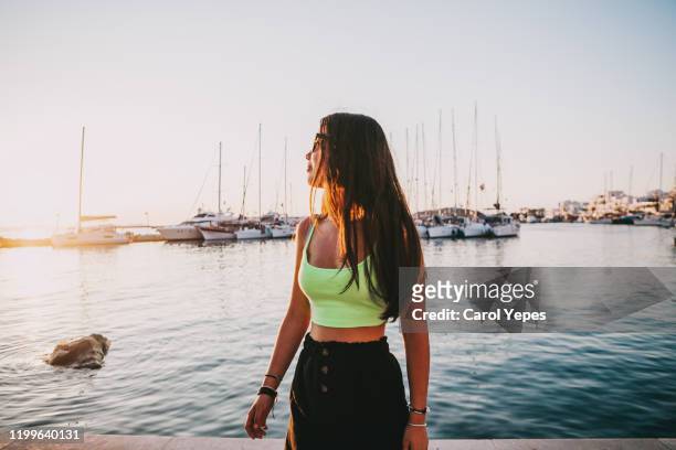young teenager girl in casual clothes looking at the sea - multi colored shirt foto e immagini stock