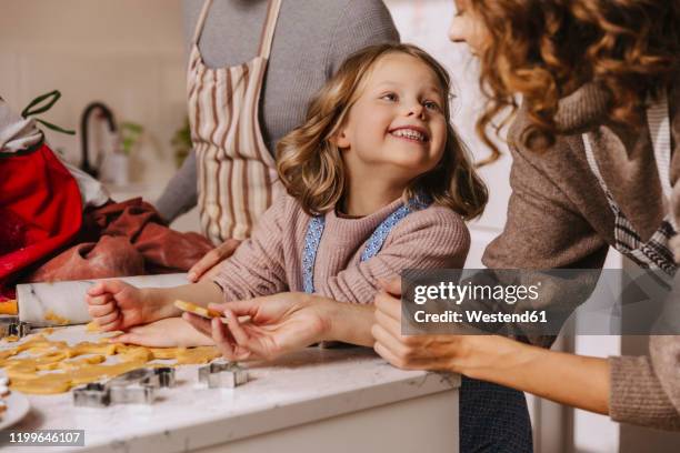 happy family preparing christmas cookies in kitchen - mother daughter baking stock pictures, royalty-free photos & images