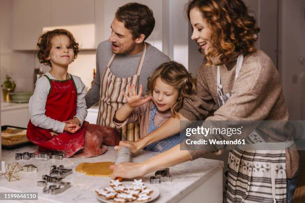 family preparing christmas cookies in kitchen - man baking cookies stock pictures, royalty-free photos & images