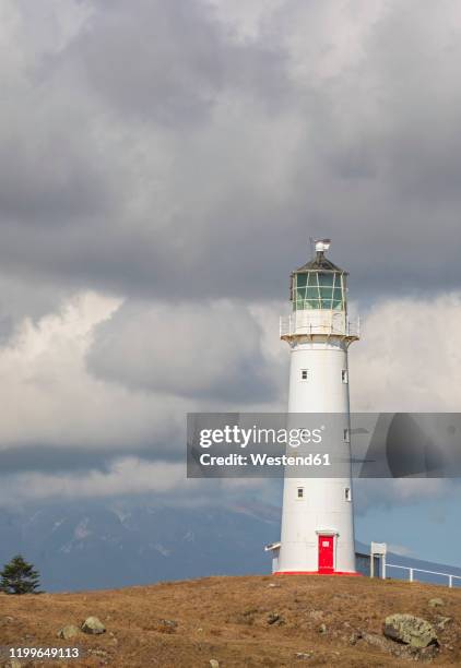 new zealand, south taranaki district, pungarehu, cloudy sky over cape egmont lighthouse - cape egmont lighthouse stock pictures, royalty-free photos & images