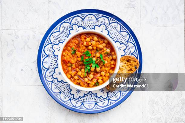 lentil and chickpea soup (red lentils, chickpeas, tomatoes, red onions, mint) - blue bowl foto e immagini stock