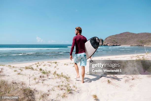 man with surfboard at the beach, sumbawa island, indonesia - surfing island ストックフォトと画像