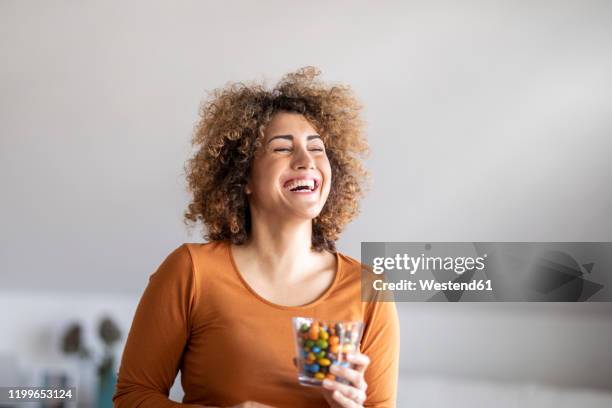 smiling mid adult woman eating a cookie - chocolate happy stock pictures, royalty-free photos & images