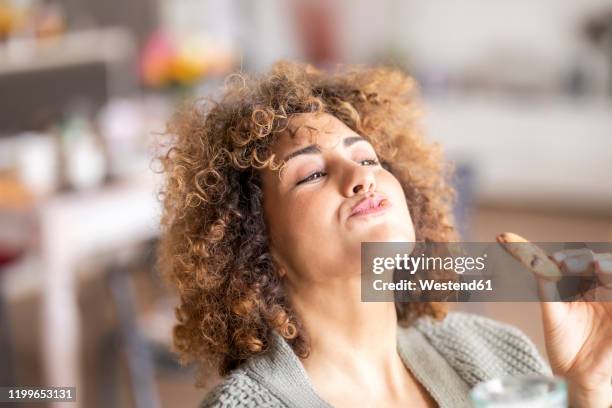 smiling mid adult woman eating a cookie - smaka bildbanksfoton och bilder