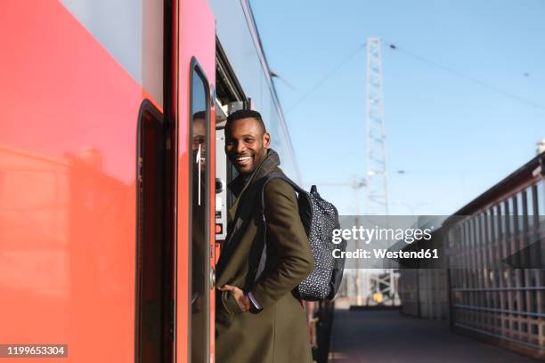 portrait of happy man entering a train - railroad station platform stock pictures, royalty-free photos & images