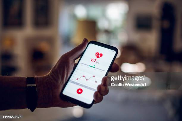 senior holding smartphone, using fitness app - checking sports stock pictures, royalty-free photos & images
