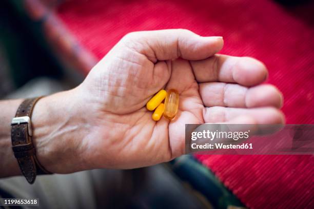 senior holding pills in his hand - tablettenbox deutsch stock-fotos und bilder