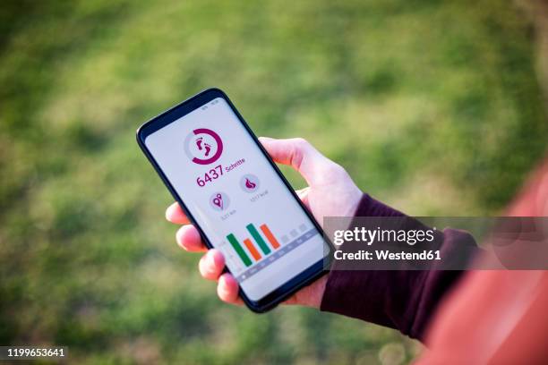 man holding smartphone, using fitness app - pedometer stock-fotos und bilder