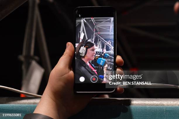 Supporter films Irish republican Sinn Fein party leader Mary Lou McDonald giving a radio interview at the Dublin City count in the RDS centre in...