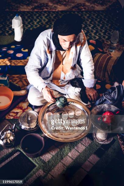 senior man in smara refugee camp pouring tea into glasses, tindouf, algeria - amazigh 個照片及圖片檔