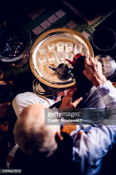 senior man in smara refugee camp preparing tea, tindouf, algeria - berbere - fotografias e filmes do acervo
